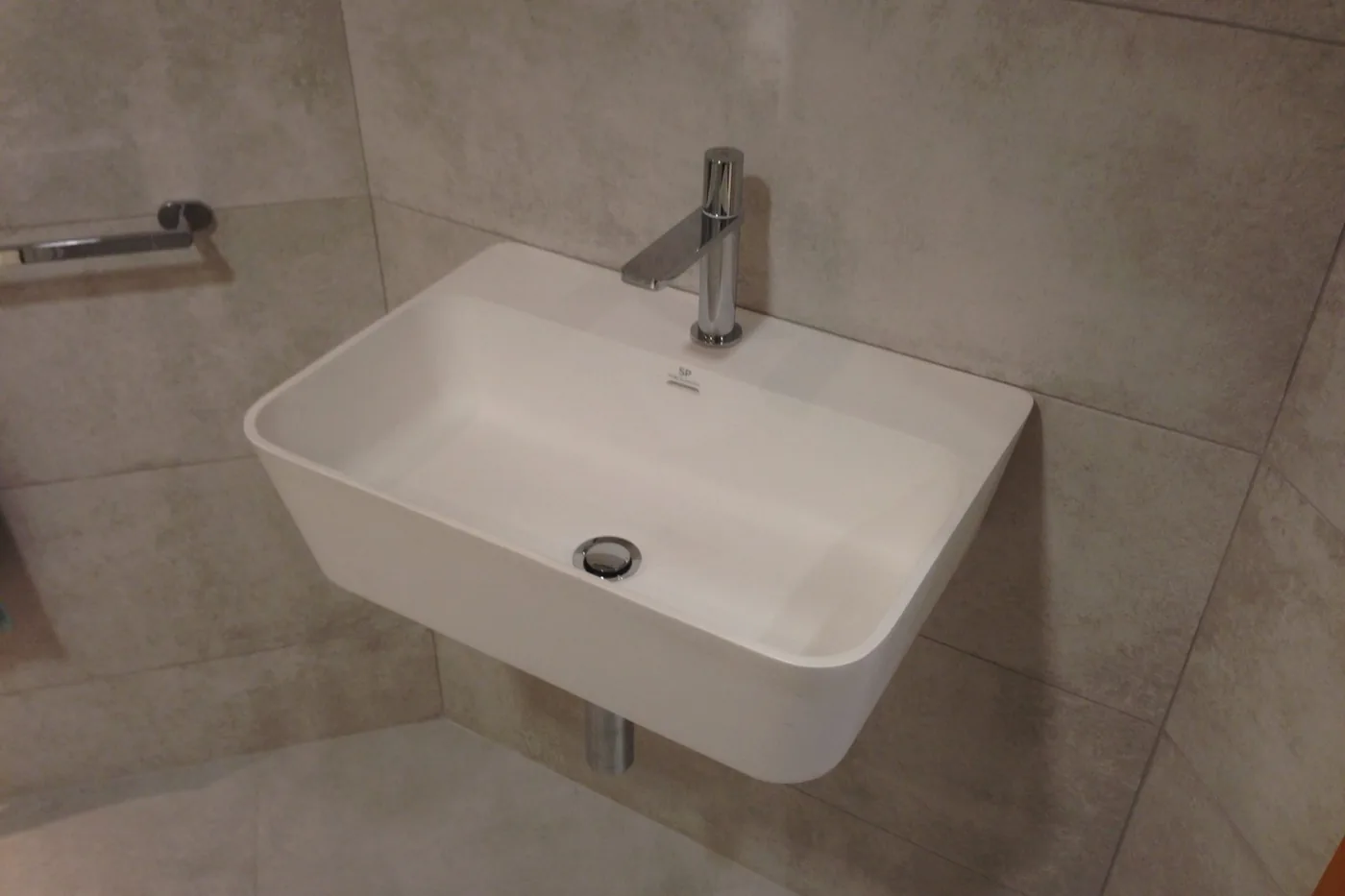 Otel banyosunda asılı lavabo ve armatür detayı