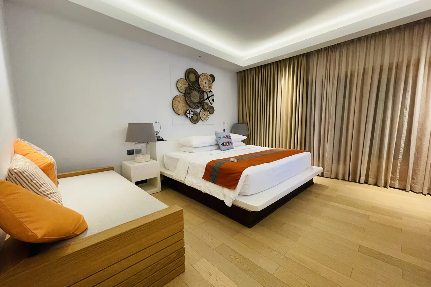 Beyaz nevresimli otel yatağı ve komodin aydınlatması